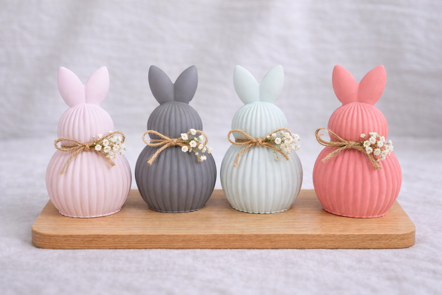 Vier bunte Hasen auf einem Holzbrett